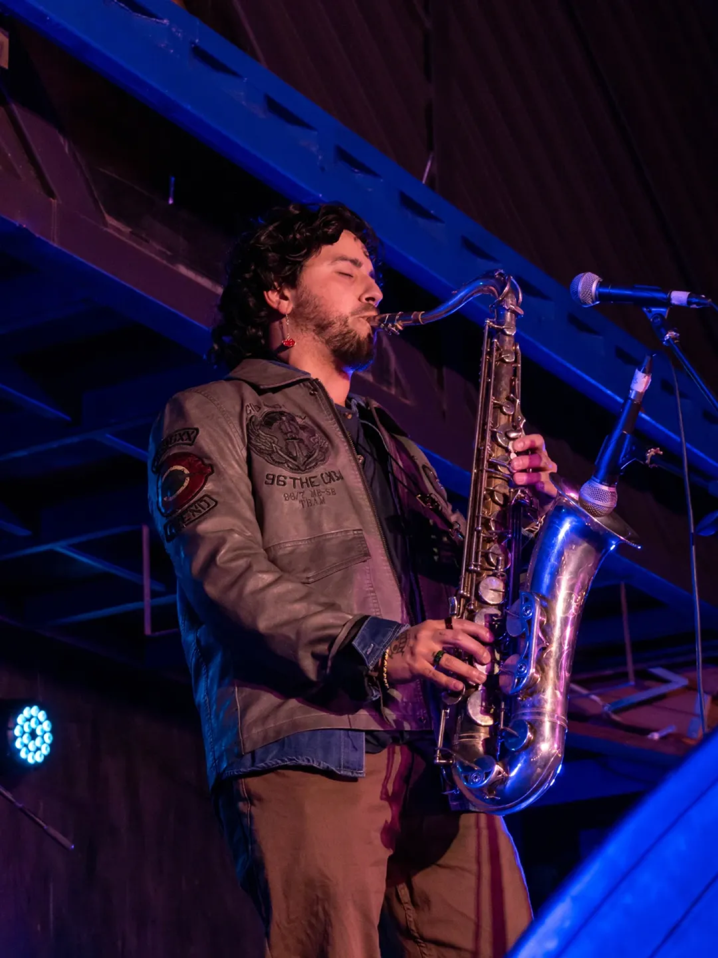 Johnny Richard tocando saxofón en vivo con iluminación azul